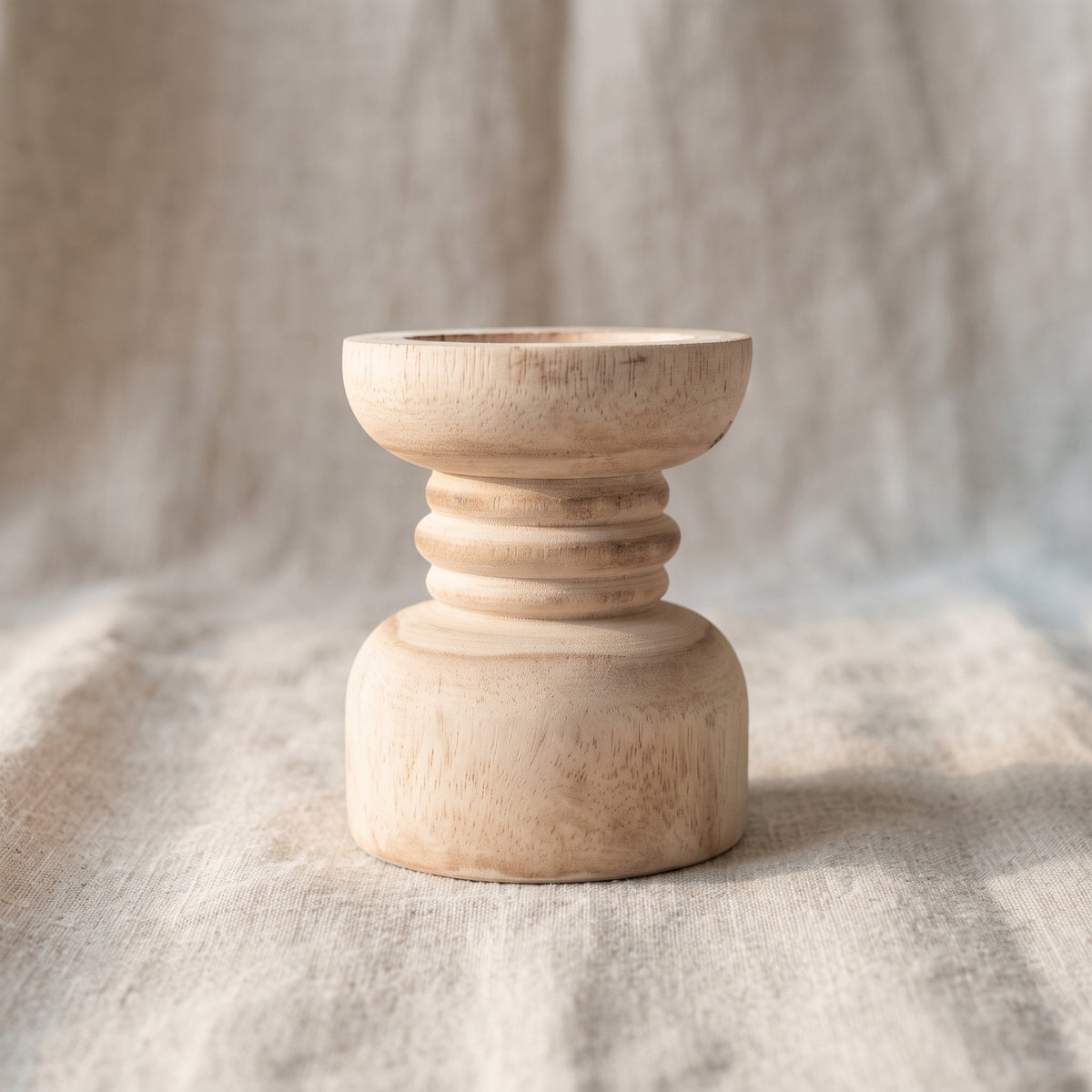 Side view of turned wooden candle holder showing curved profile and rings